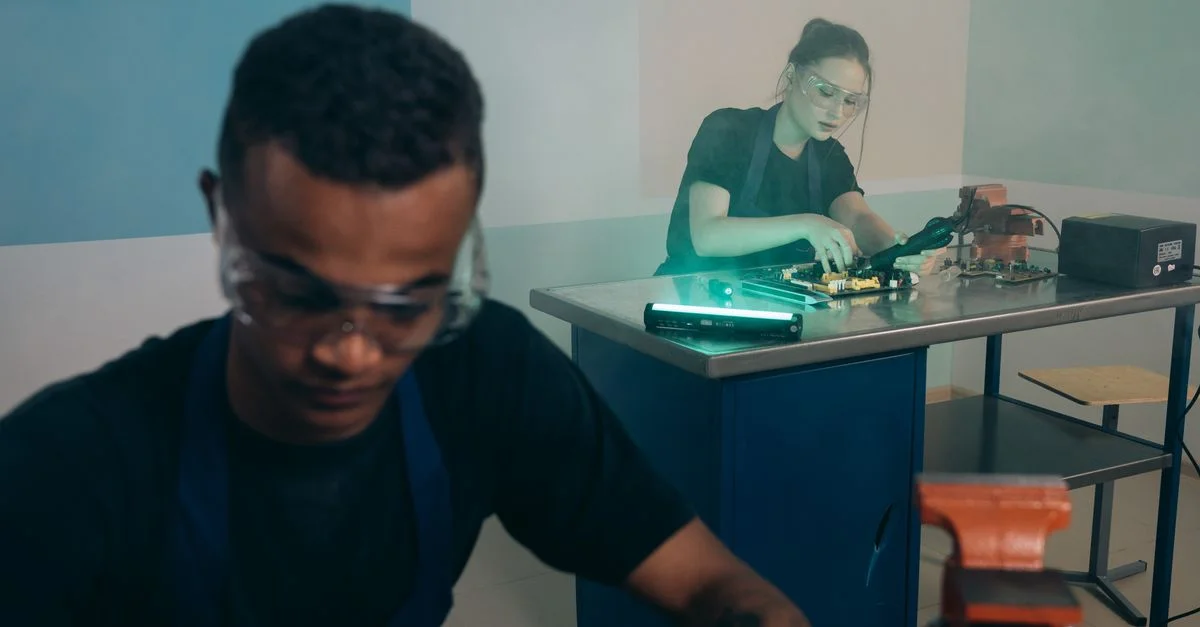 Deux techniciens concentrés sur la réparation d'électronique dans un atelier moderne.