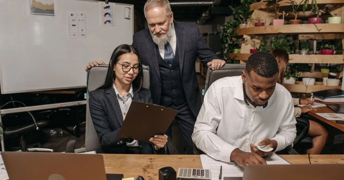 Un groupe diversifié de professionnels travaillant dans un bureau moderne avec des ordinateurs portables et des documents.