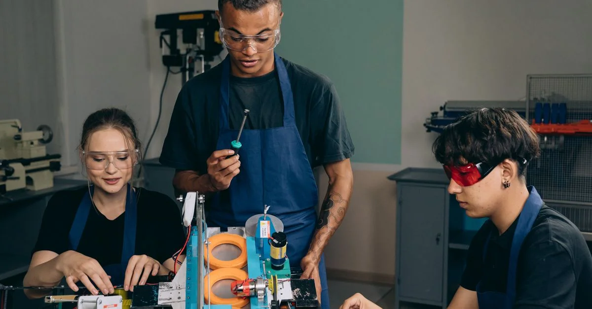Équipe d'ingénieurs travaillant avec des outils et équipements dans un atelier moderne.
