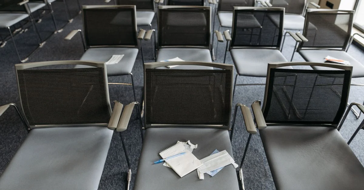 Vue en plongée d'une salle de conférence vide avec des chaises modernes disposées en rangées.
