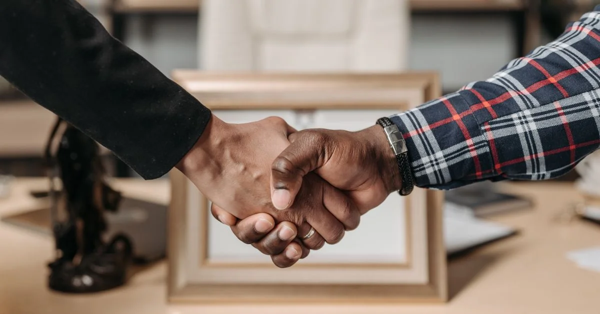 Gros plan d'une poignée de main entre deux professionnels dans un environnement de bureau.